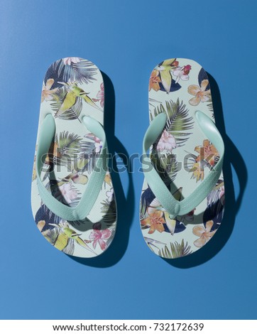 flower print flip flops on blue background