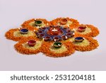 Flower Rangoli for diwali festival made using marigold with clay diya lamps.