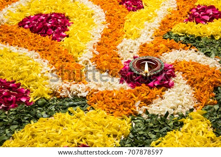 Flower Rangoli for Diwali or Pongal Festival made using Marigold or Zendu flowers and Rose petals over white background, selective focus