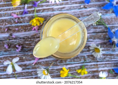 Flower royal jelly pot in close-up surrounded by flowers