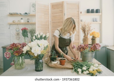 Flower shop. Girl florist makes a beautiful spring bouquet