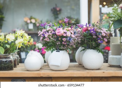 Flower Shop Indoors. Flowers In Vase With Empty Tag. Soft Yellow, Green, Pink, Red Violet And Purple Colors. 