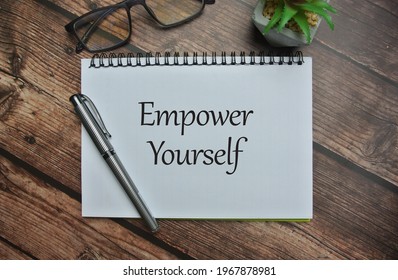 Flower, Spectacle, Pen And Notebook Written With EMPOWER YOURSELF On Wooden Background. Student, Life, Motivation Quote, Spirit, Awareness And Upgrade Skill Concept.