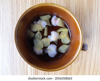 Flower Tea In Brown Cup, With Hot Water, Yellow Cosmos Flower And Light Pink Kamantigue Flower Petals.