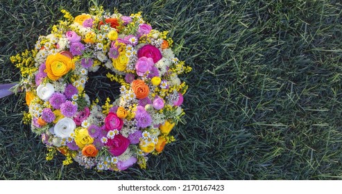 Flower Wreath On Green Grass. Fresh Wild Flowers And Herbs On Garden Lawn, Top View. Spring Day. Women Or Mothers Day Celebration, Copy Space