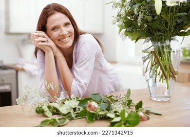 Flowers always bring a smile to peoples faces. Portrait of a beautiful woman in the process of arranging a bouquet of flowers.