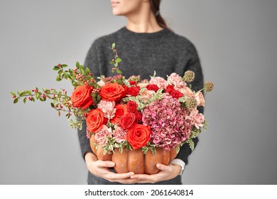 Flowers Arrangement In Pumpkin In Women Hands. Fresh Cut Flowers For Decoration Home. European Floral Shop. Delivery Fresh Cut Flower.