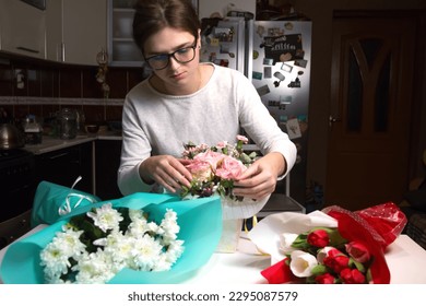 Flowers background. Florist create beautiful bouquets at night. Small business. Female florist in a flower shop. Woman wrapping bouquet. Arranging a bouquet of beautiful colorful flowers Out of focus. - Powered by Shutterstock