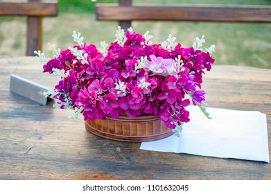 Flowers In Basket On Dinner Table And Paper Napkin