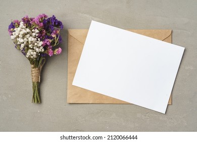 Flowers, blank paper and envelope on a table top view - Shutterstock ID 2120066444