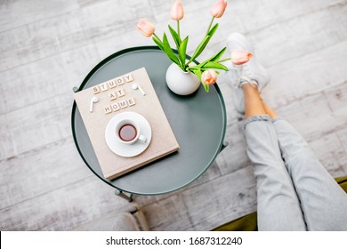 Flowers, Books And Cup Of Coffee On A Round Table Indoors, Top View. Study At Home And Cozy Home Atmosphere Concept