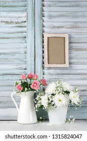 Flowers Bouquets On Wood Table Against Vintage Wooden Shutters With Empty Photoframe. Shabby Chic Style.