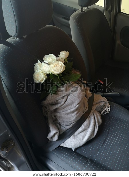 flowers in a car with the seat belt on. transporting\
fragile flowers. 