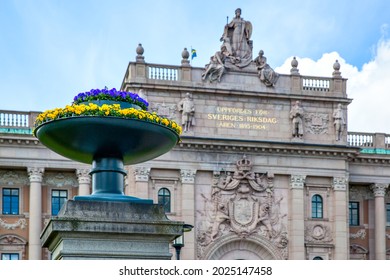 Flowers with colors of swedish flag in front of the Parliament of Sweden (Sveriges Riksdag) in Stockholm
