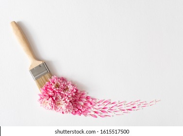 Flowers composition. Creative layout made of pink and white flowers and paint brush on white background. Flat lay, top view, copy space.