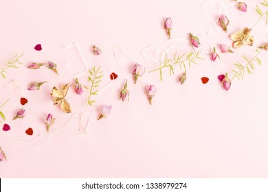 Flowers composition. Frame made of dried rose flowers on pink background.
