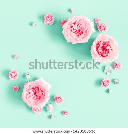 Flowers composition. Frame made of rose flowers on mint background. Flat lay, top view, copy space, square