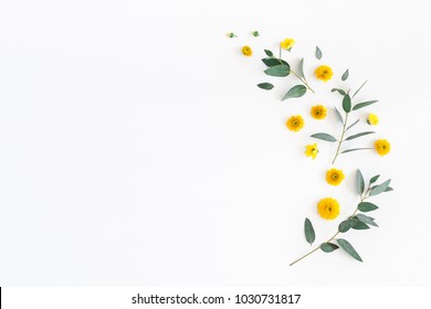 Flowers composition. Pattern made of yellow flowers and eucalyptus leaves on white background. Flat lay, top view, copy space