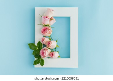 Flowers Composition. Photo Frame, Rose Flowers On Pastel Blue Background. Valentines Day, Mothers Day, Womens Day, Spring Concept. Flat Lay, Top View, Copy Space