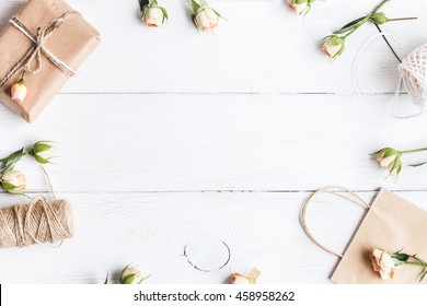 Flowers Composition. Workspace With Rose Flowers, Gift, Paper Bag. Top View, Flat Lay.