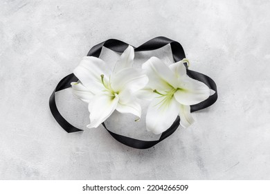 Flowers Heads Of White Lilies With Black Ribbon. Mourning Or Funeral Background