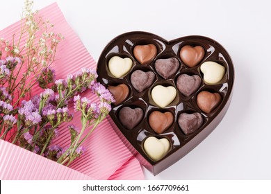 Flowers With Heart Shaped Box Of Chocolates On White Background