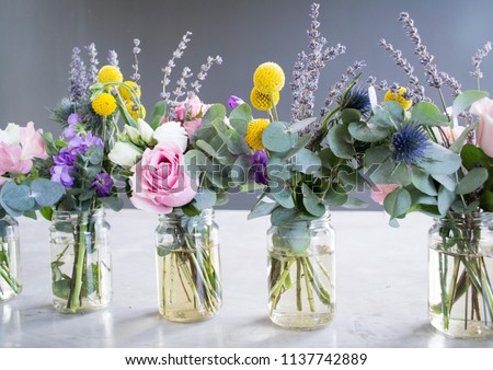 Flowers in jar, beautiful bouquet on table on gray background
