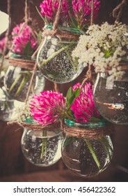 Flowers in jars on a string.