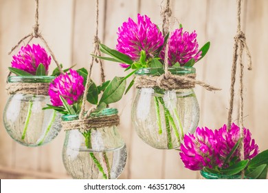 Flowers in jars on a string.