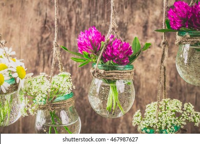Flowers in jars on a string.