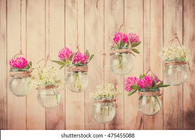 Flowers in jars on a string.