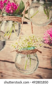 Flowers in jars on a string.