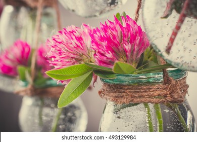 Flowers in jars on a string.