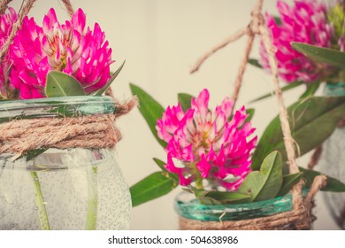 Flowers in jars on a string.