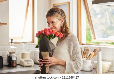 Flowers, smile, and elderly woman smelling rose in a kitchen, surprised by sweet gesture and or secret gift. Happy, romantic and kind surprise for mature, excited woman on valentines morning - Powered by Shutterstock