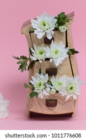 Flowers in wooden box on a pink background.