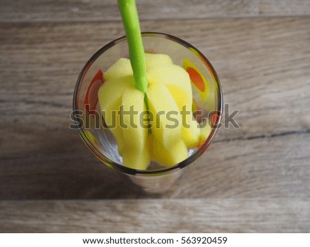 Flower-shaped sponge to wash the glasses on wood background
