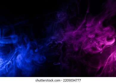Flowing clouds of colorful swirling blue and pink smoke dark abstract background