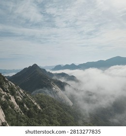 Flowing clouds rest against the lofty mountain, unable to cross.