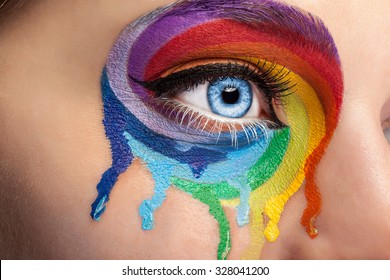 Flowing Colors On An Eye In Fashion Stage Make Up. Rainbow Of Color Spectrum. Blue Eye. Close Up Details. Macro Shooting. Fashion On Stage Make Up. Vibrant Colors