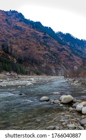 flowing river having rocks in the river and having beautiful mountains in the background