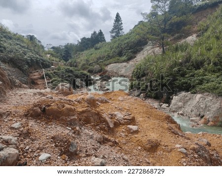 A flowing river with a hot water source. The river contains sulphur. Sulphur deposits accumulate around the banks and at the bottom of the river. The water from this river is very good for skin health