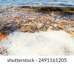 Flowing wave on the sea sandy beach at sunset. Summer vacation background and coastal nature concept. wave water and rocks near the shore. Wave on sea surface. Natural background.