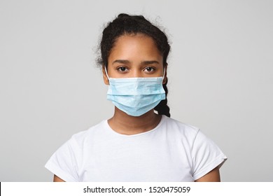 Flu Concept. Teen African Girl With Protective Face Mask, Grey Studio Background