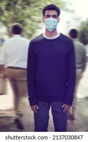 Flu Season Is Here. Shot Of A Man Wearing A Surgical Mask In A Crowd.