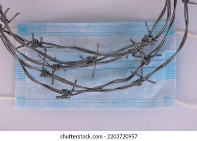 Flu Season, Medical Mask And Barbed Wire On A Light Background.