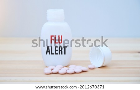 Flu text alert on white glass jar. Flu season concept.