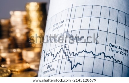 Fluctuating prices of Dax, Dow Jones and FTSE with stacks of money in the background as a symbol for turbulent times on the stock exchange