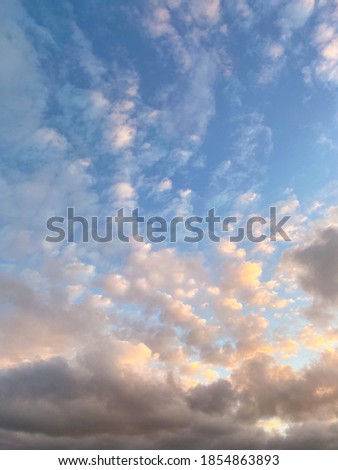 Fluffly clouds in the blue sky during sunset 