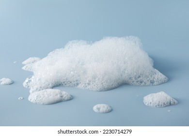 Fluffy bath foam on light blue background - Powered by Shutterstock